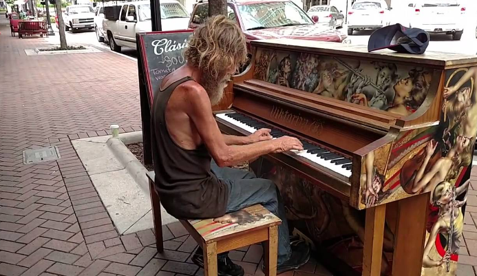 Người vô gia cư chơi đàn trên đường phố